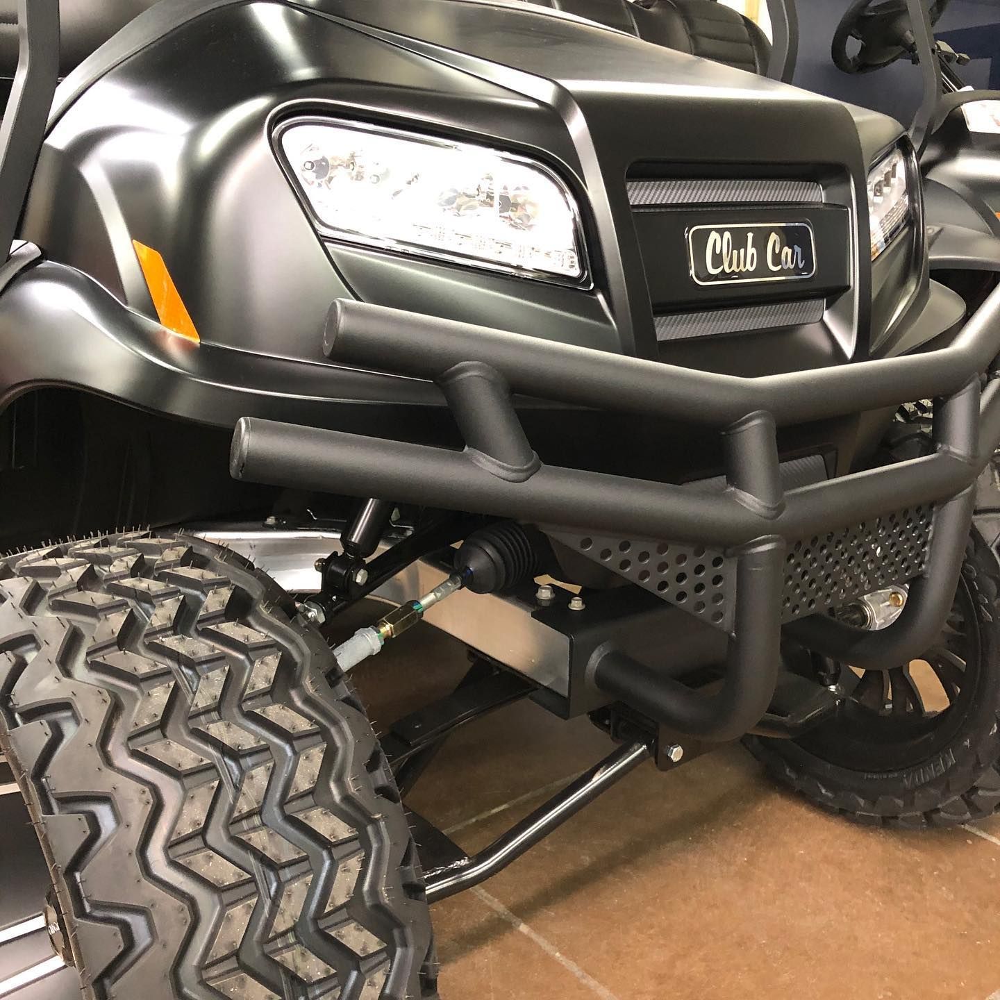 A black golf cart is parked in a garage.