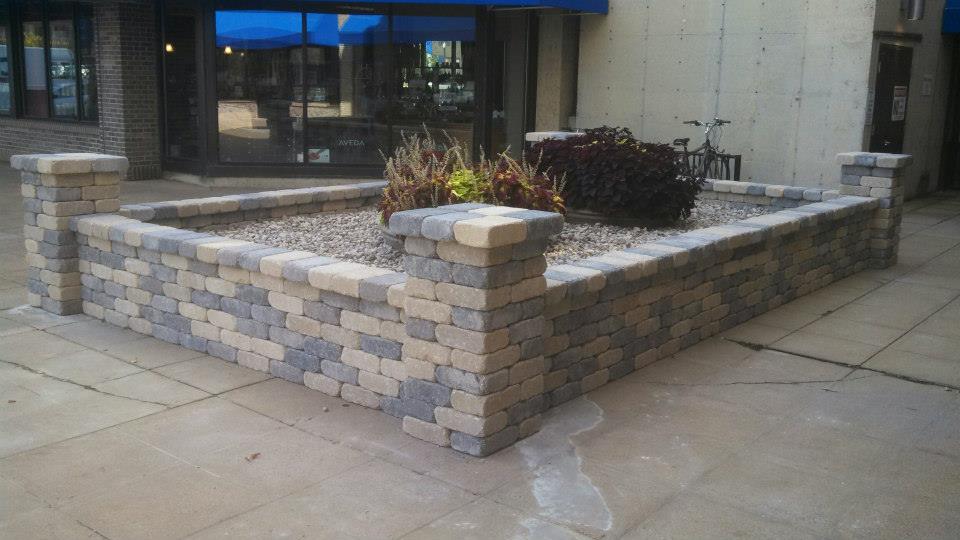 Now the shops have something attractive to look out on, and it even helps screen the bike rack in the back. The random blending of the tan and gray blocks help tie in both the concrete and brick colors in the area.