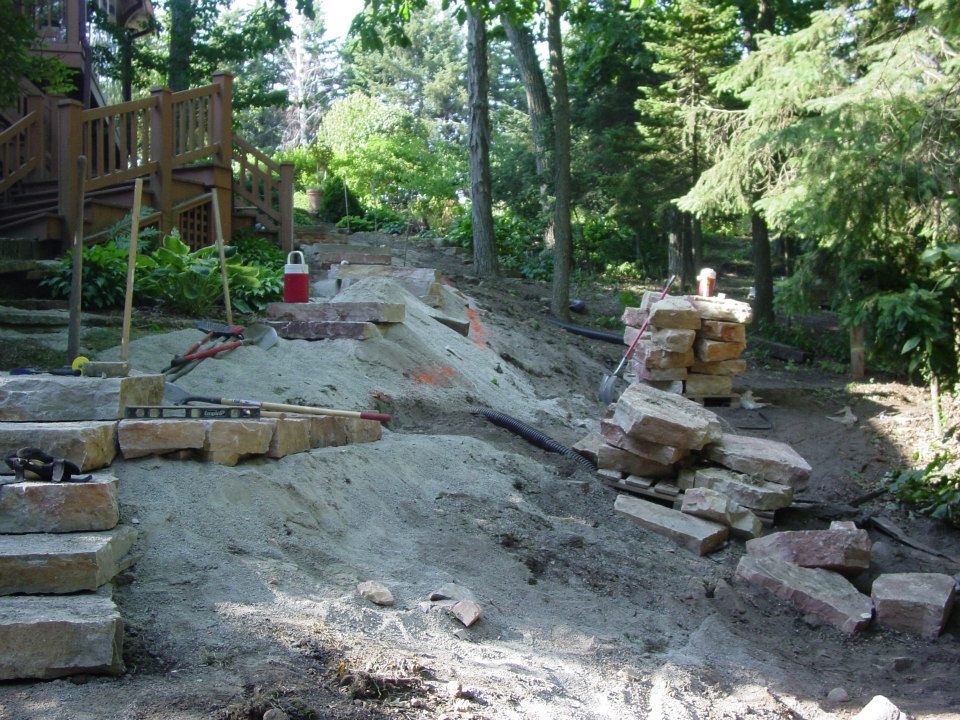 A work in progress. Drain tiles are buried and steps are in ... now for the side walls, topsoil, boulders and mulch.