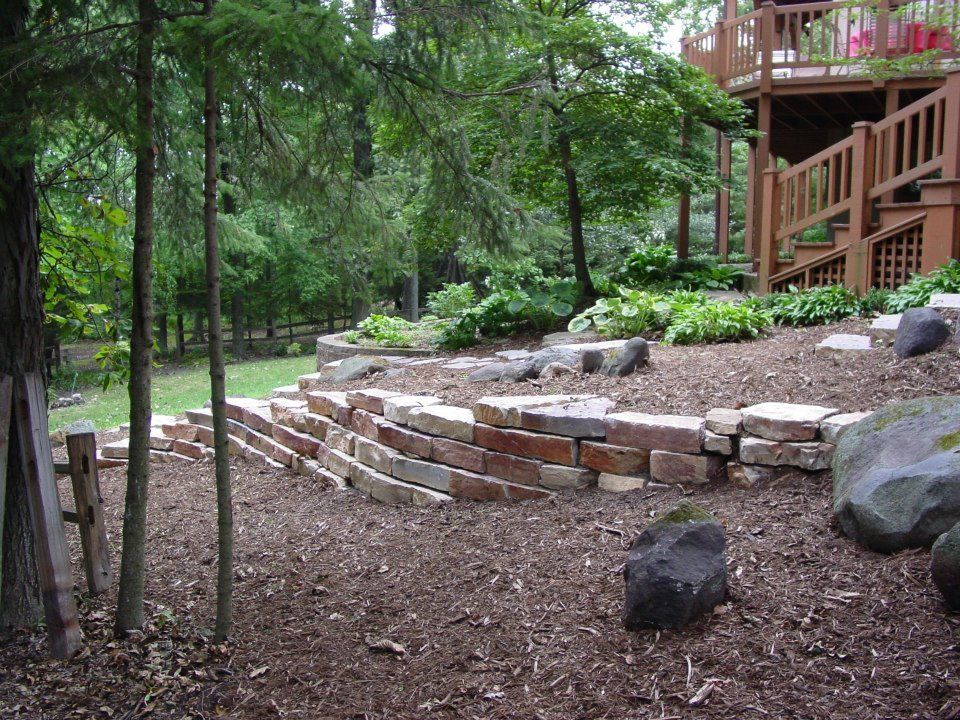 Weatheredge stone wall on the side for erosion control and terraced planting areas.