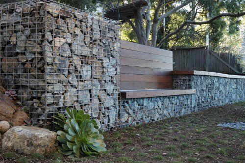 A wooden bench is sitting next to a stone wall.