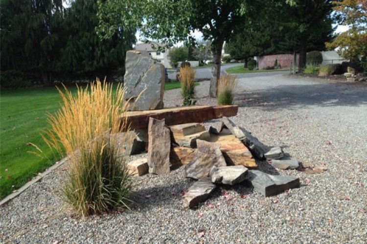 A wooden bench is sitting on top of a pile of rocks.