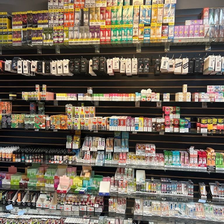 Shelves filled with various vape products, including cartridges and devices, in a retail store setting.