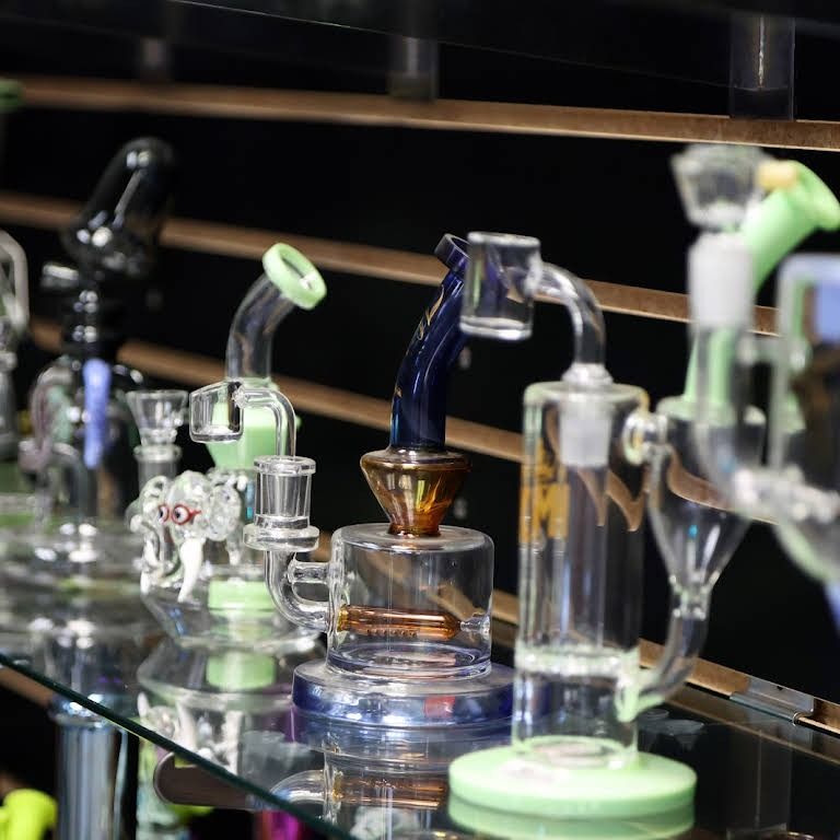 Glass water pipes for sale on a shelf, showcasing different colors and designs.