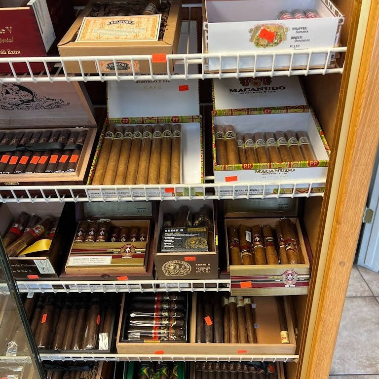Cigar display case with various boxes of cigars. Brown, tan, and beige colors.