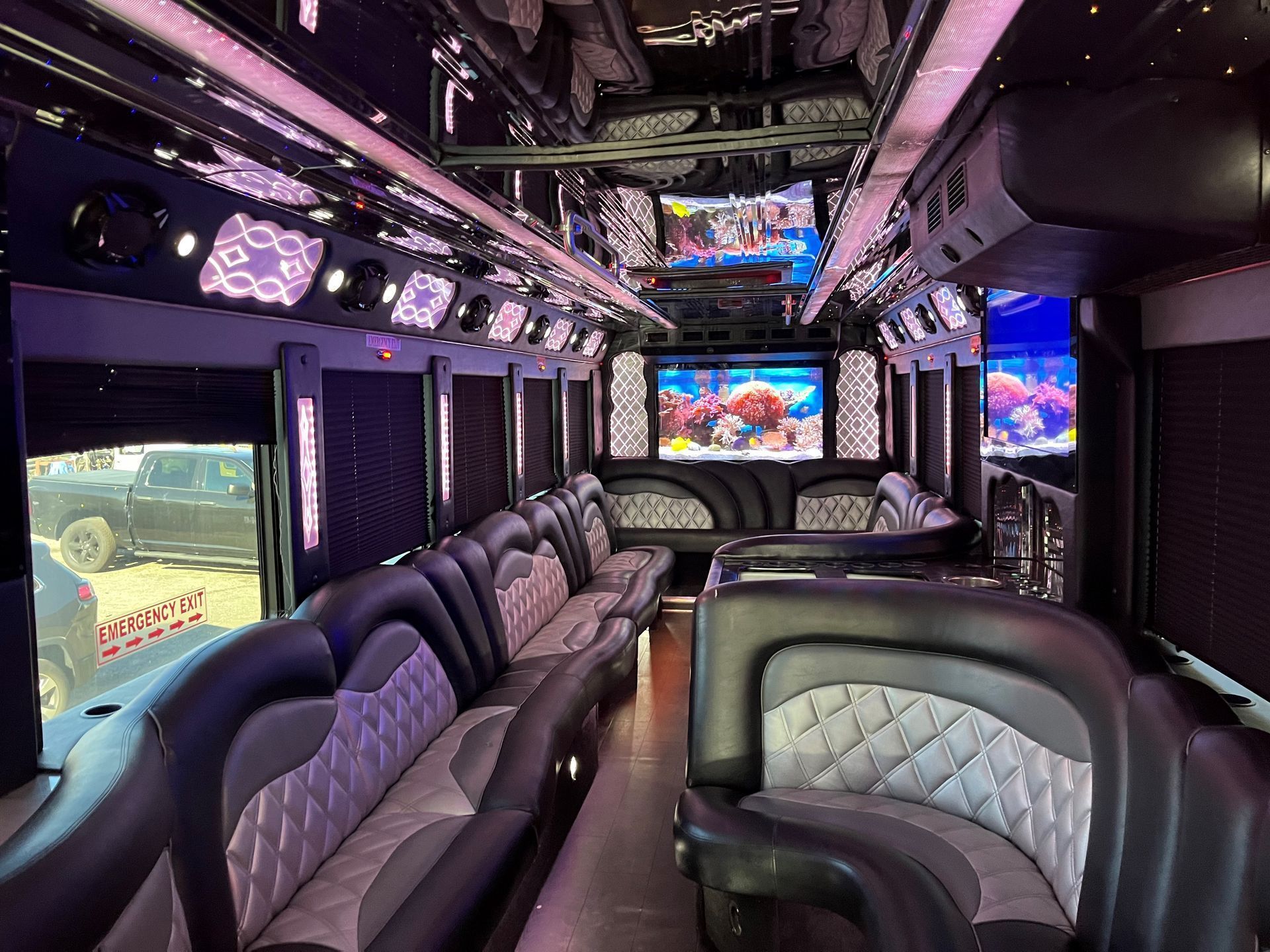 The inside of a limousine with a lot of seats and a television.