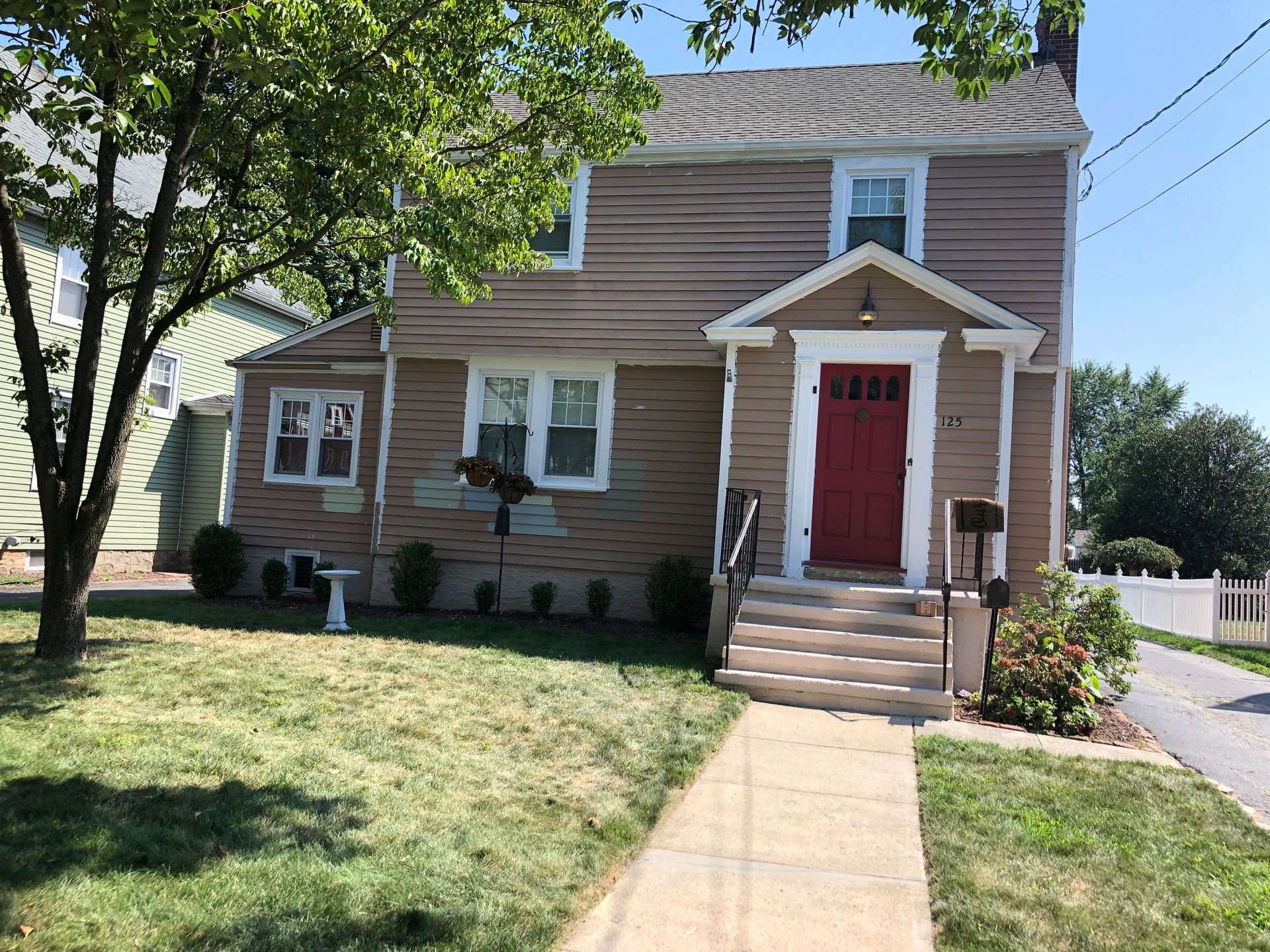 The front of a house with a red door and white trim.