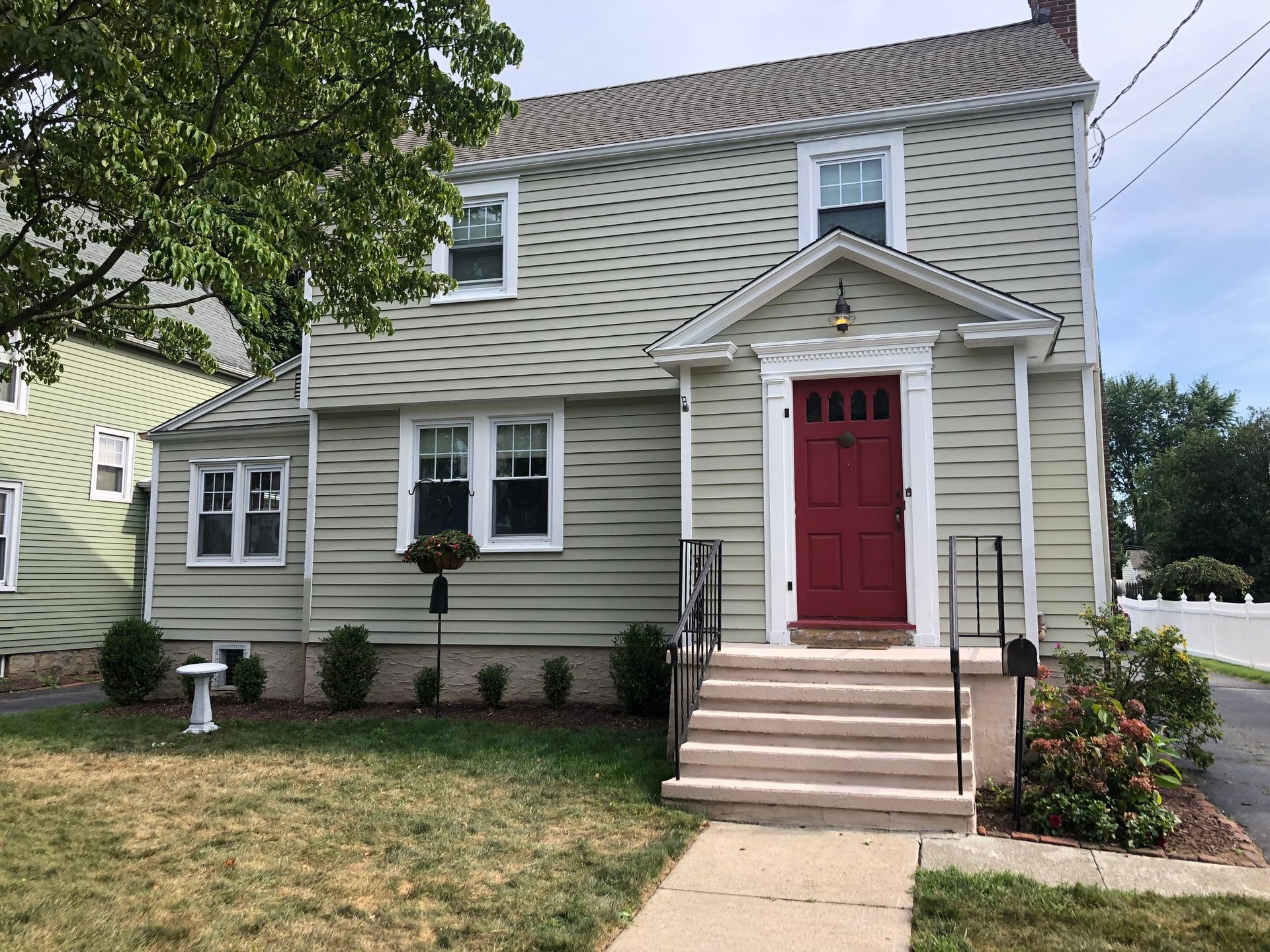 A house with a red door and stairs in front of it.