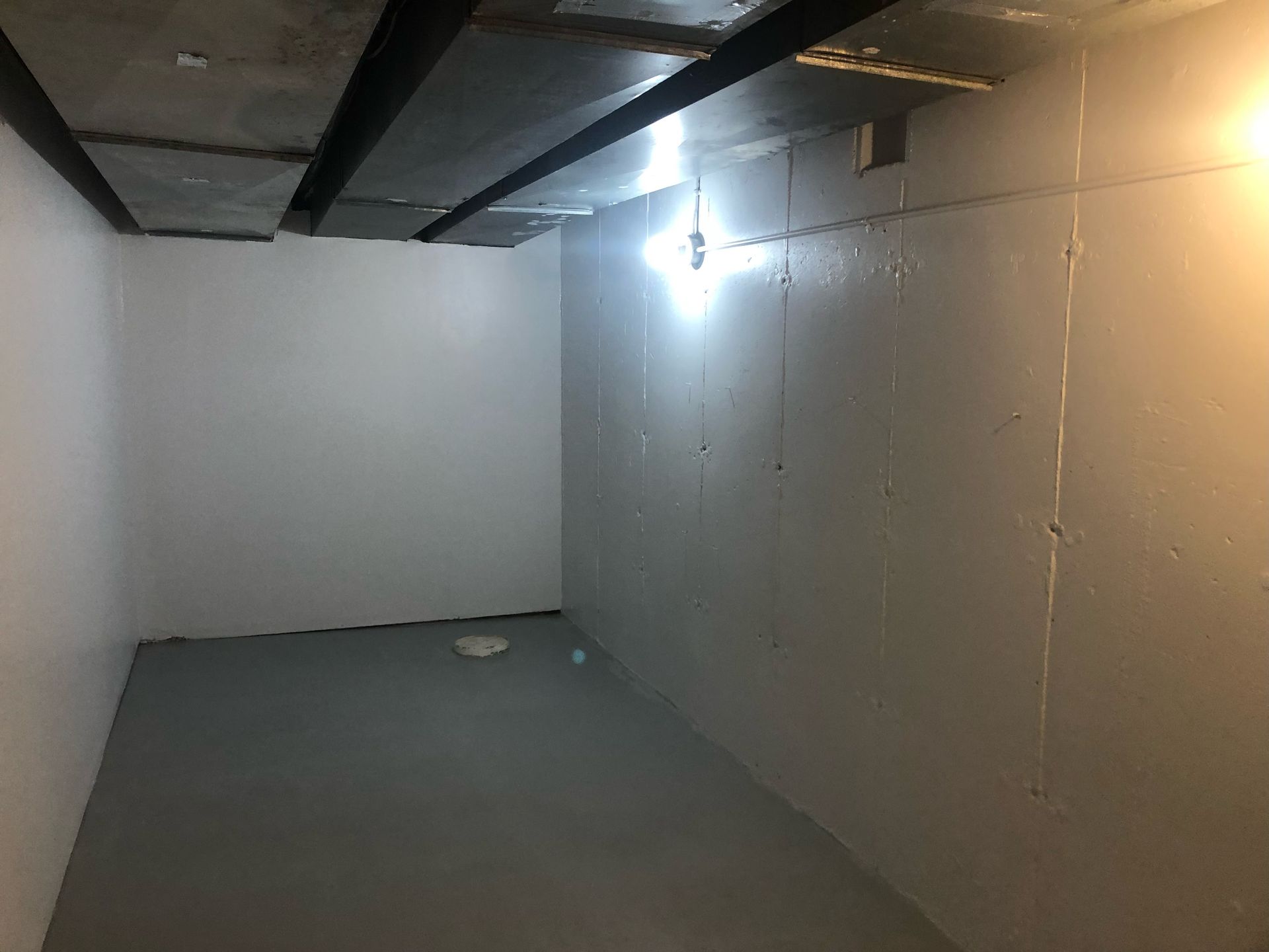 An empty room with white walls and a light on the ceiling.