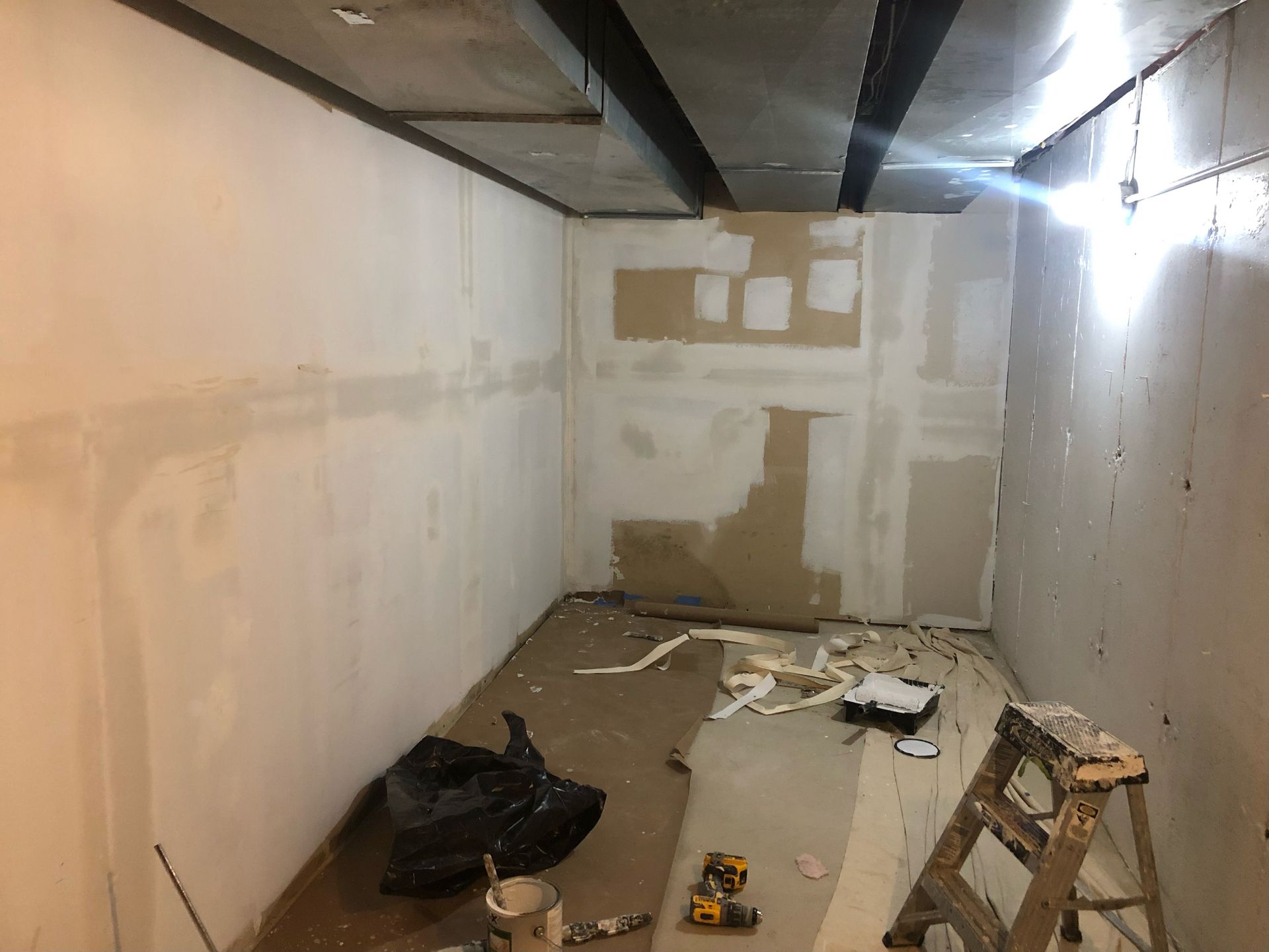 A room with white walls and a ladder in it.