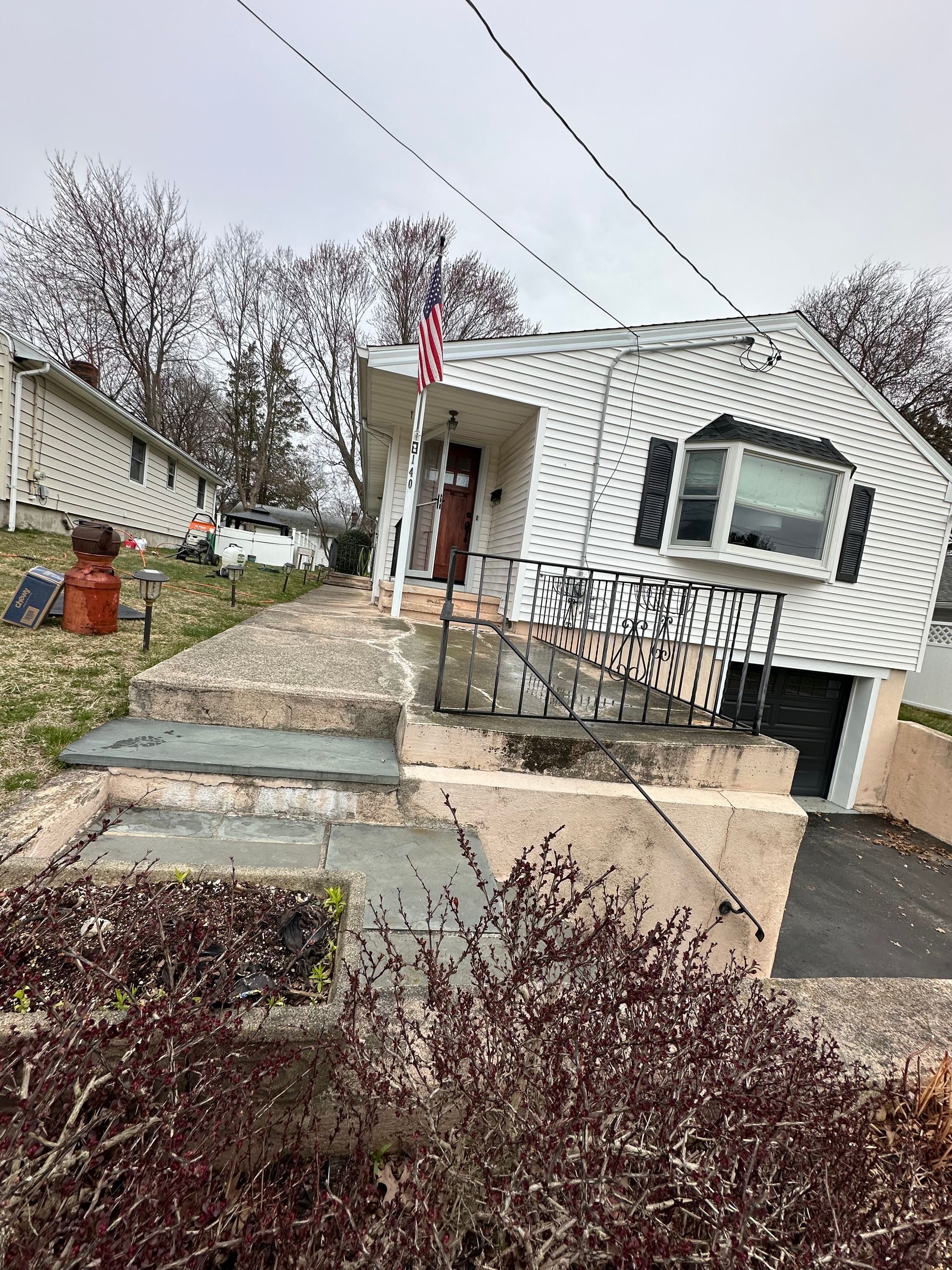 A white house with a red flag on the front porch.