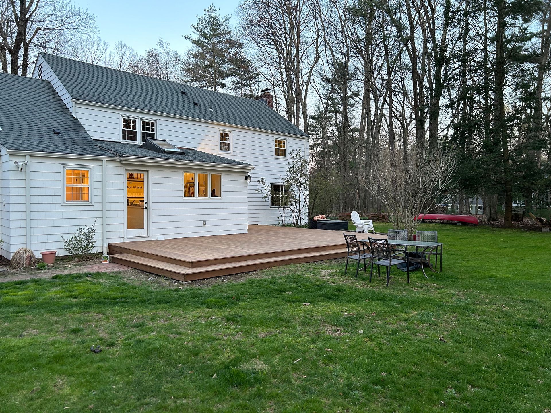 A large white house with a large deck in the backyard.