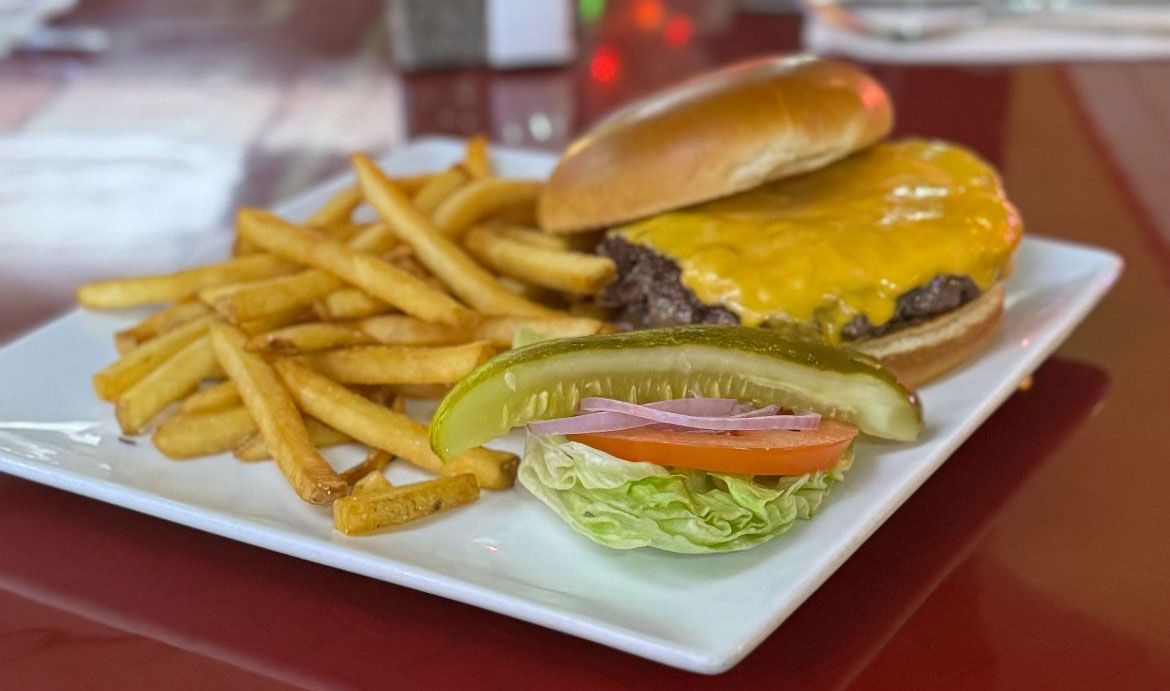 Caesar salad with lettuce, croutons, and cheese on a white plate, resting on a bamboo mat.