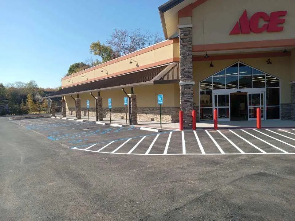 The exterior of an Ace Hardware store featuring a row of designated handicap parking spaces in front of the building.
