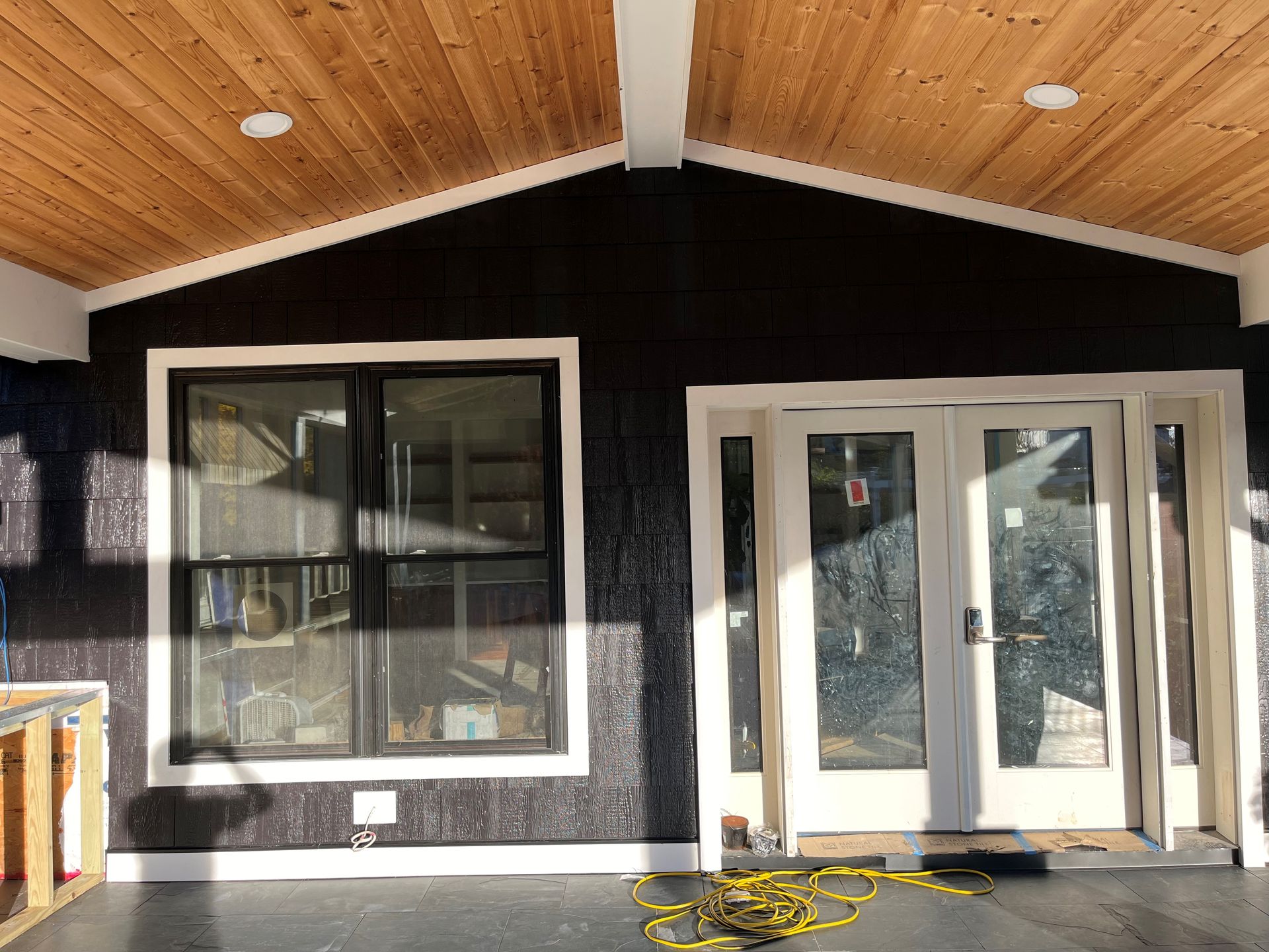 A house with a wooden ceiling and a lot of windows and doors.