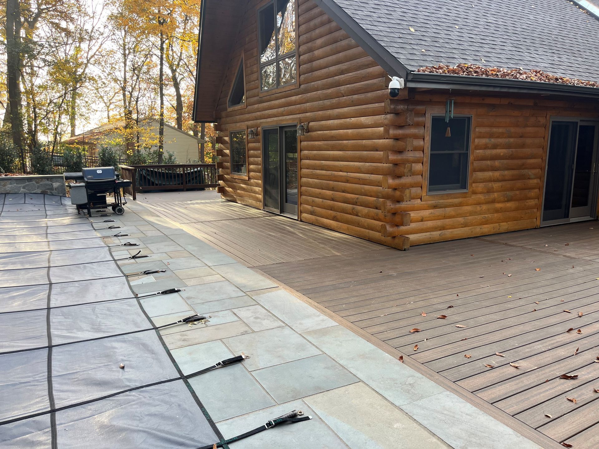 A large log cabin with a patio in front of it