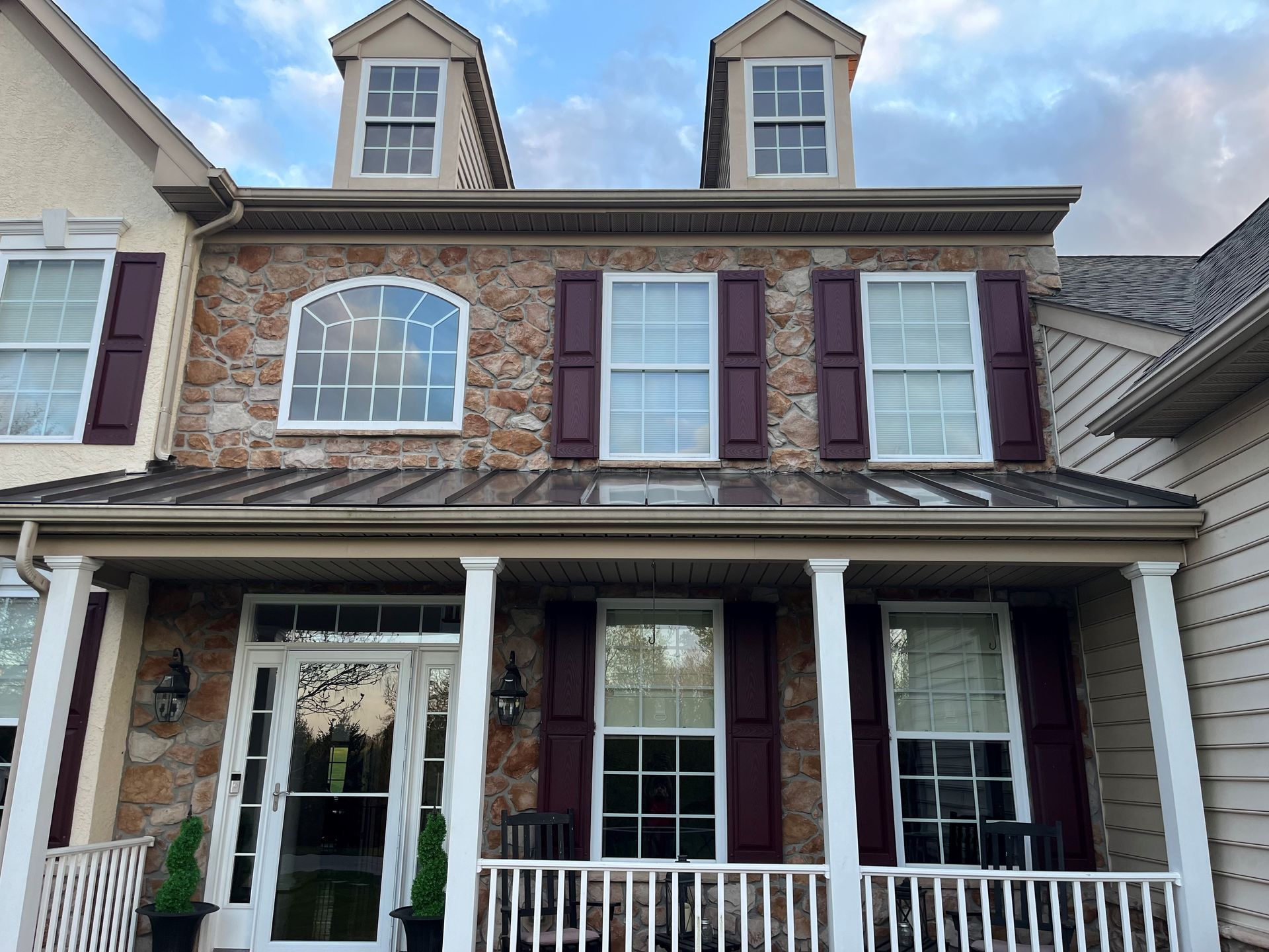 The front of a house with a porch and shutters