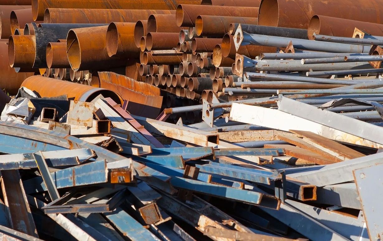 Pile of rusty and painted scrap metal at a recycling yard.