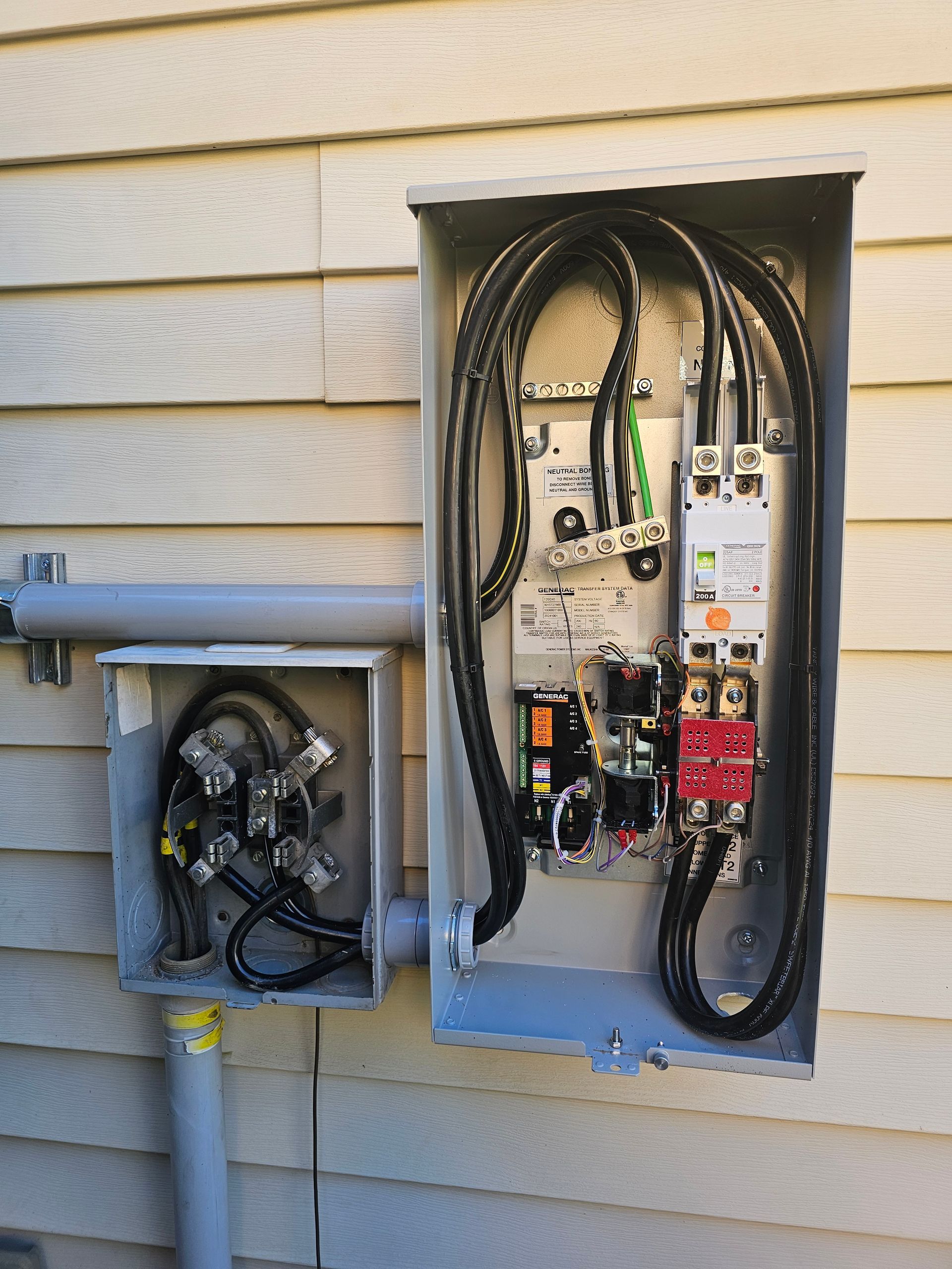 An electrical box on the side of a house with a lot of wires coming out of it
