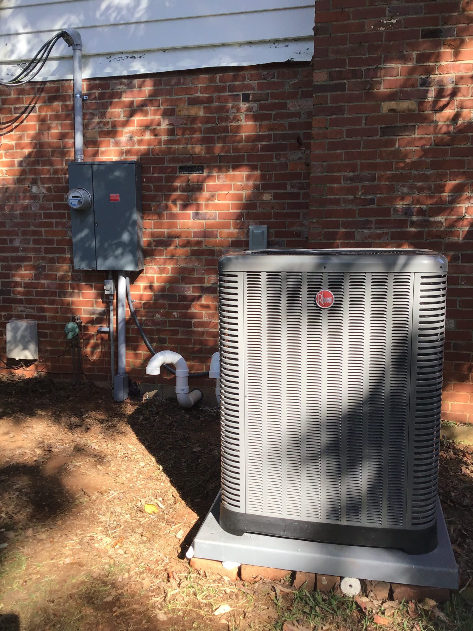 An air conditioner is sitting on the side of a brick building
