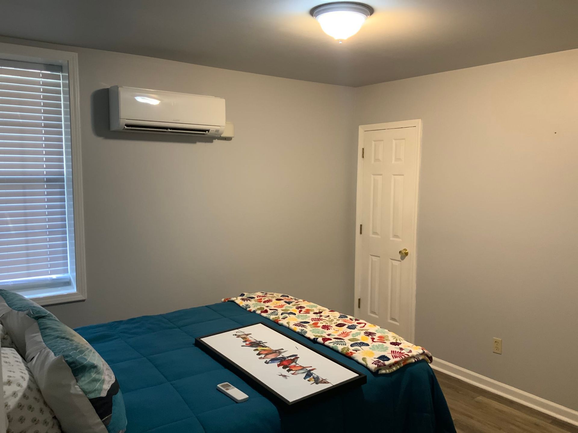 A bedroom with a bed, window, and air conditioner