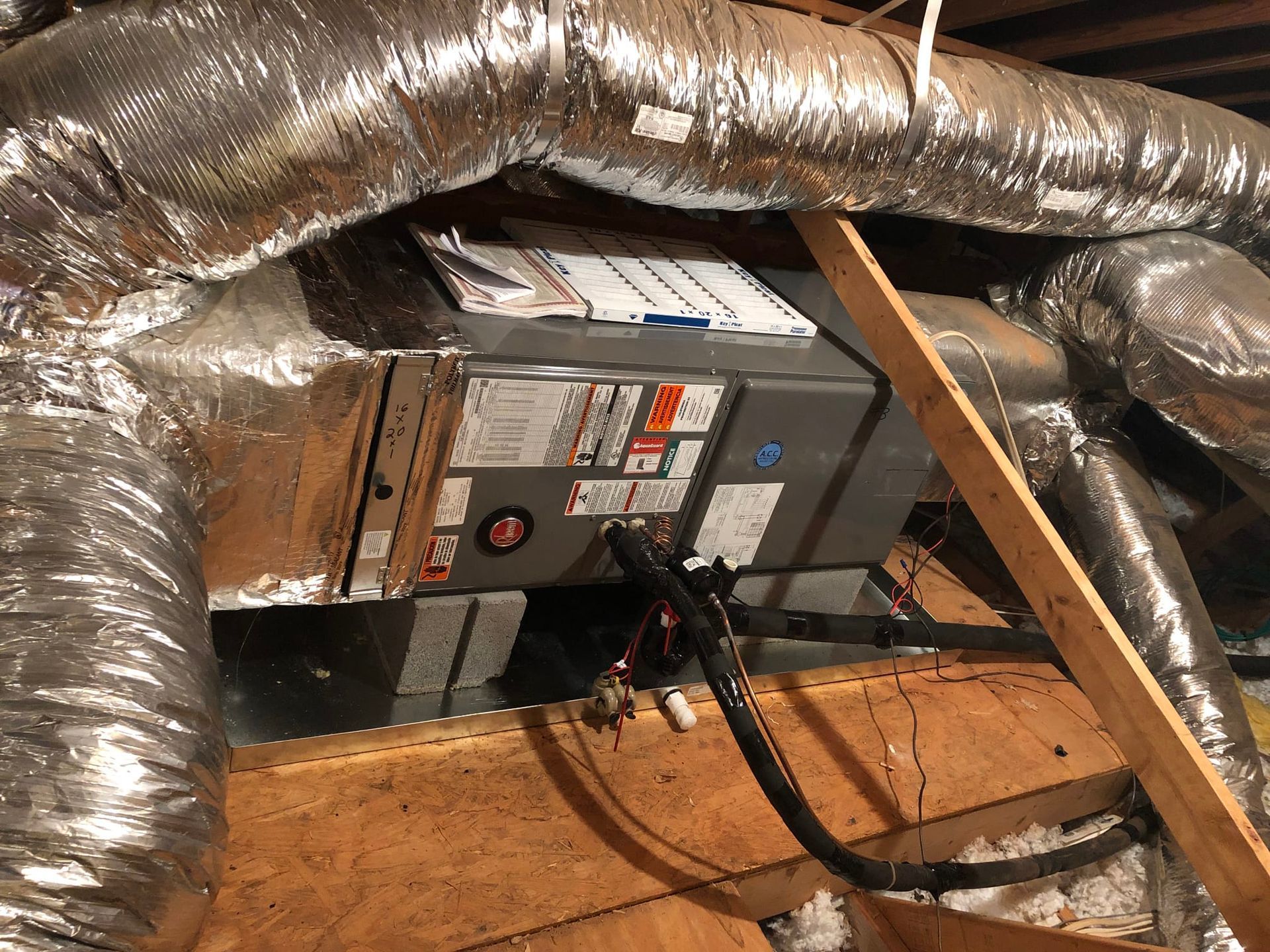 An air conditioner is installed in the attic of a house