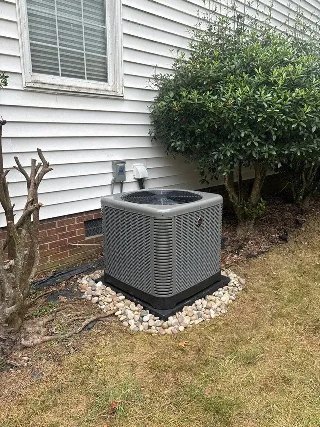 An air conditioner is sitting in the backyard of a house