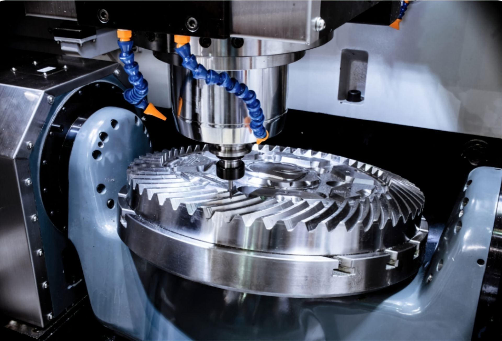 A metal gear workpiece being machined on a 5-axis CNC milling machine with coolant nozzles visible.