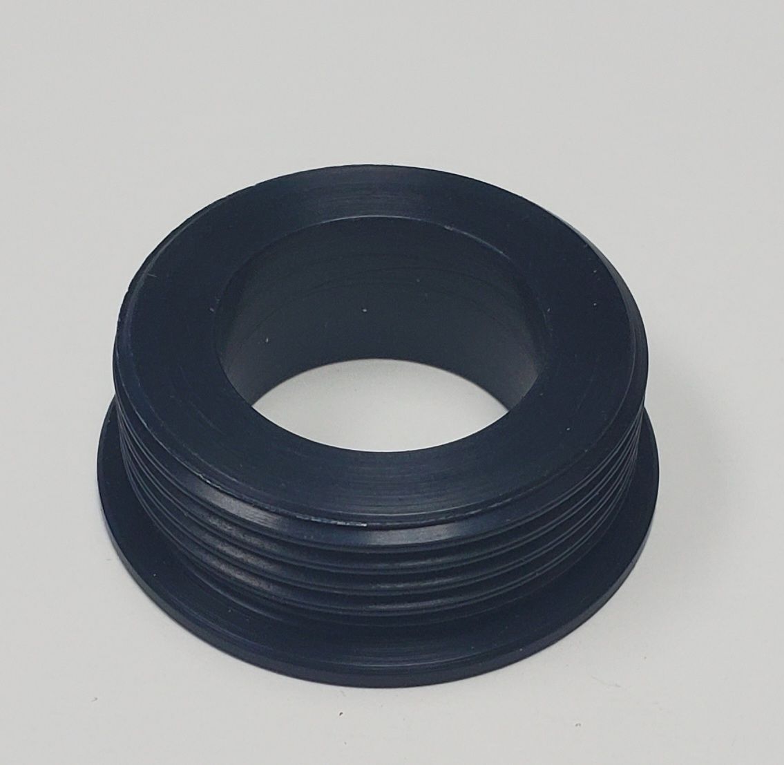 A black, cylindrical threaded bushing or spacer component shown against a neutral background.