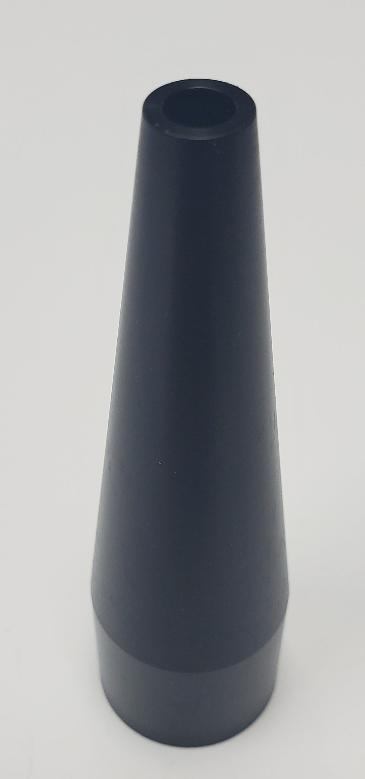 A black, conical-shaped plastic nozzle standing upright against a plain white background.