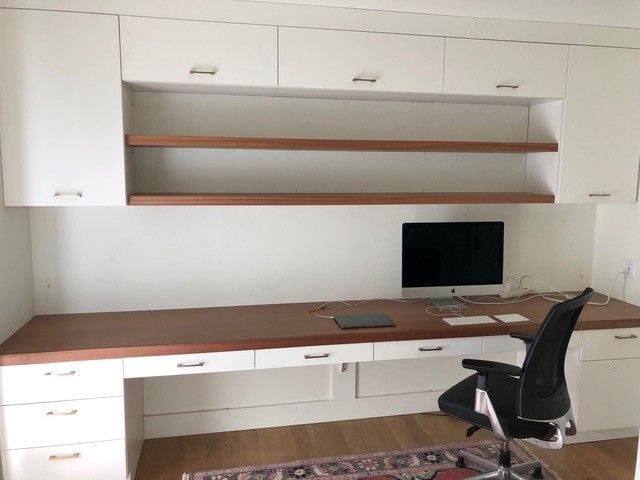 Built-in white desk with overhead cabinets
