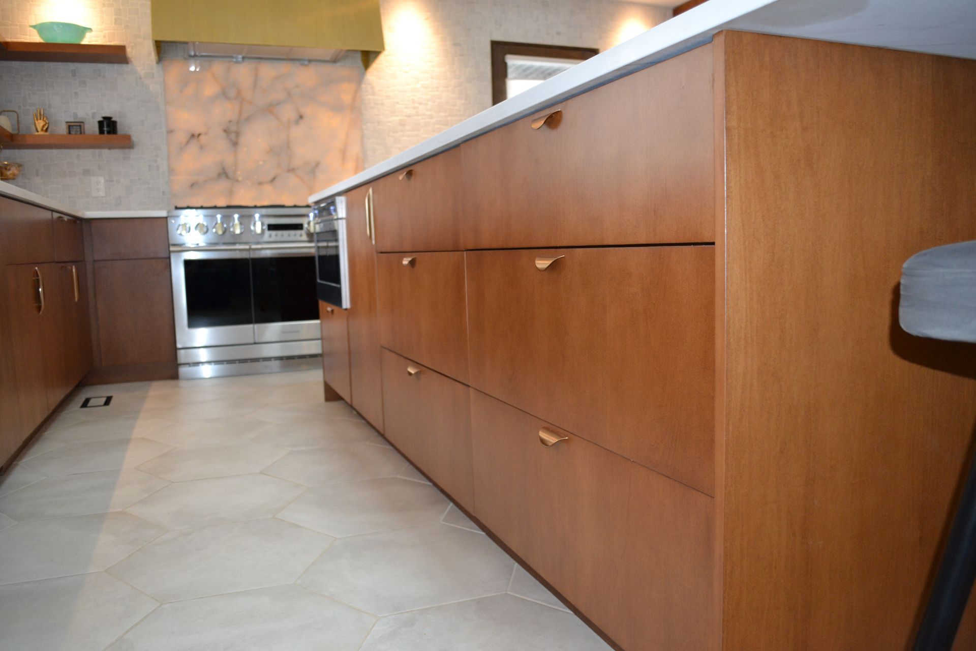 Wooden kitchen cabinets with light countertops and tile flooring.