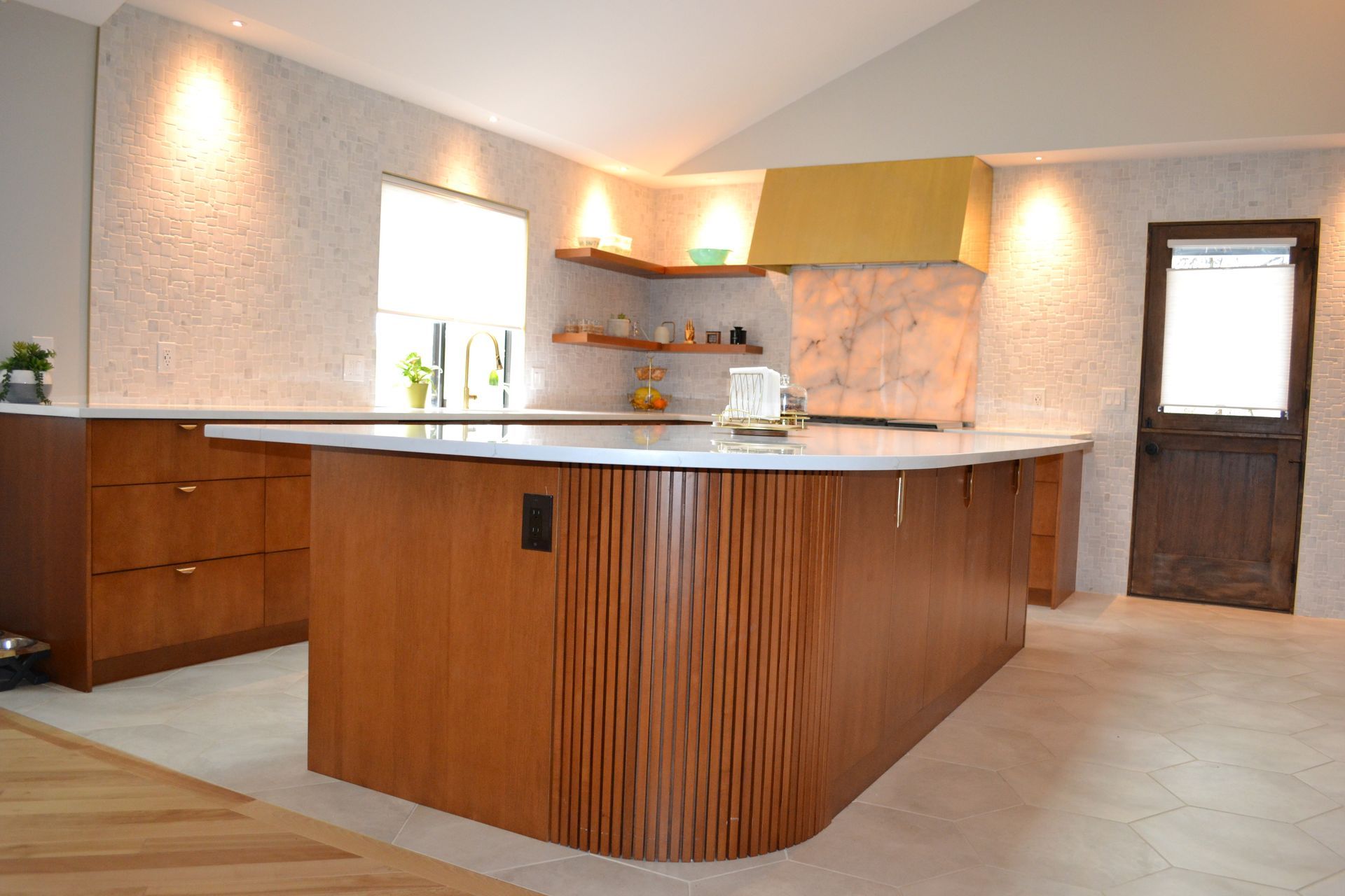 Modern kitchen with a curved wooden island and textured backsplash.