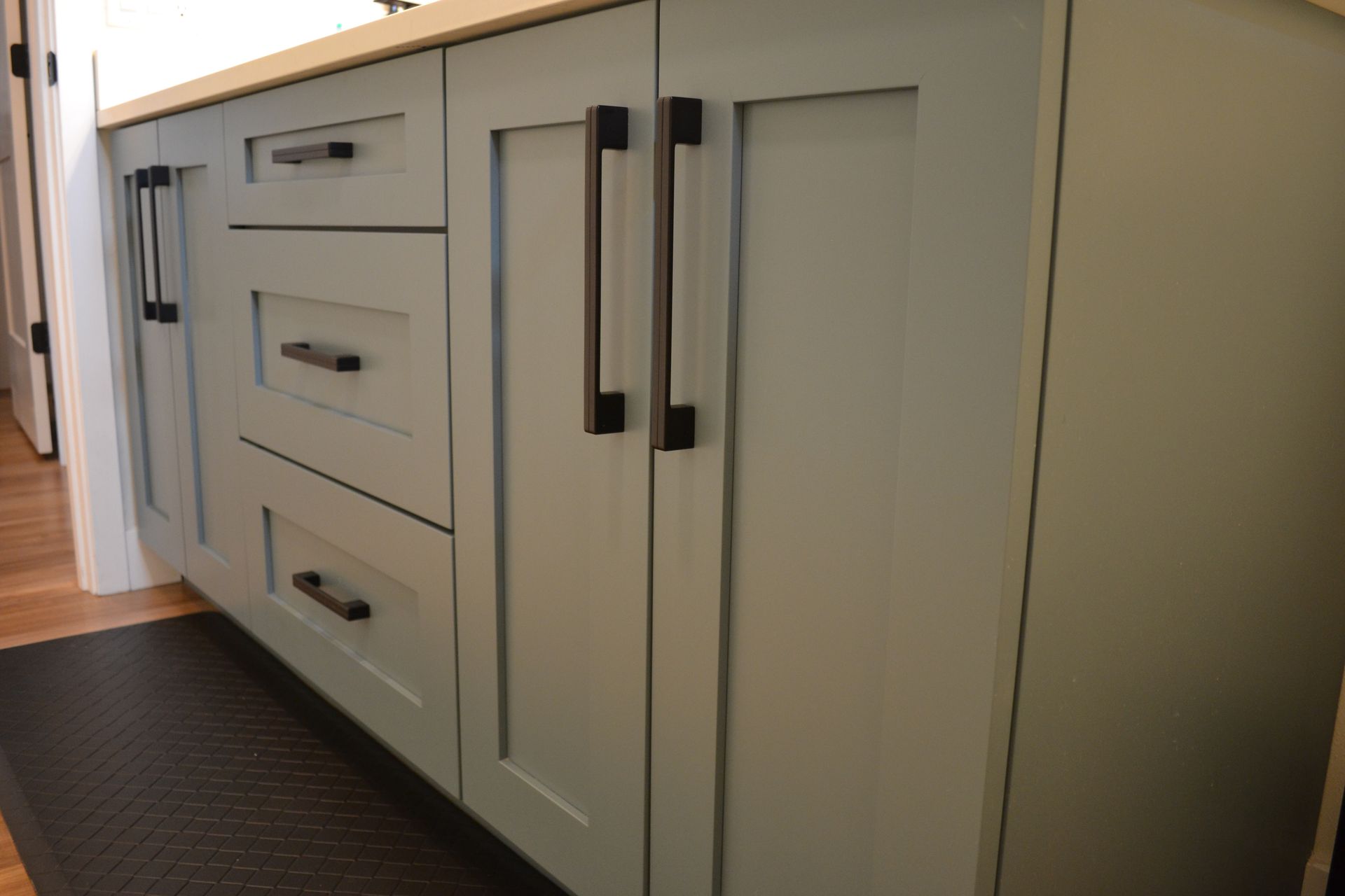 Pale green bathroom vanity with black hardware.