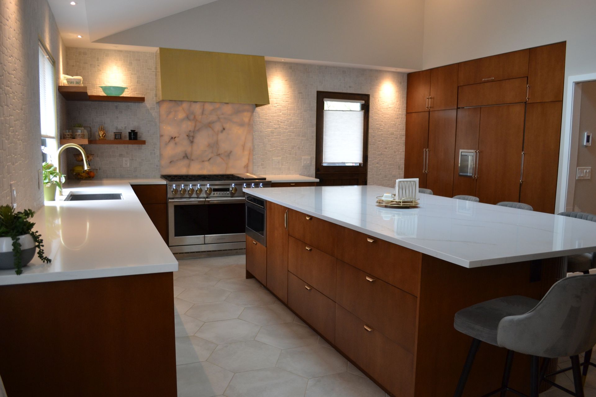 Modern kitchen with wood cabinetry, white countertops, and stainless steel appliances.