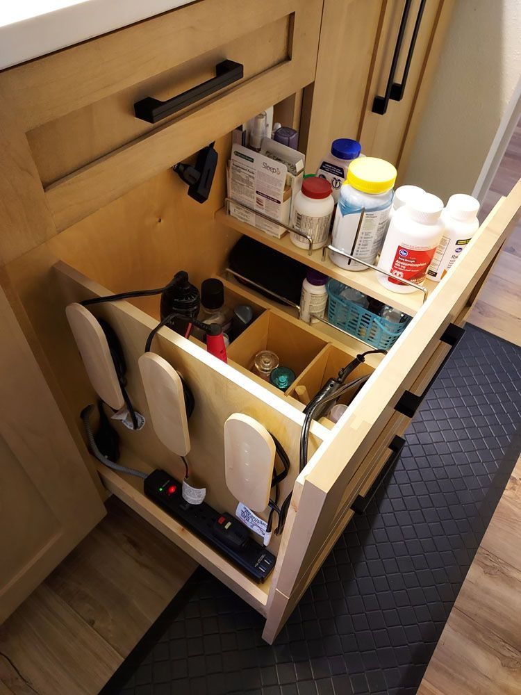 Wooden cabinet drawer with organized medications and grooming tools.