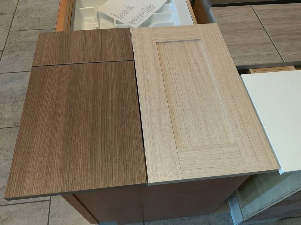 Two wooden cabinet doors, one dark brown, the other light.