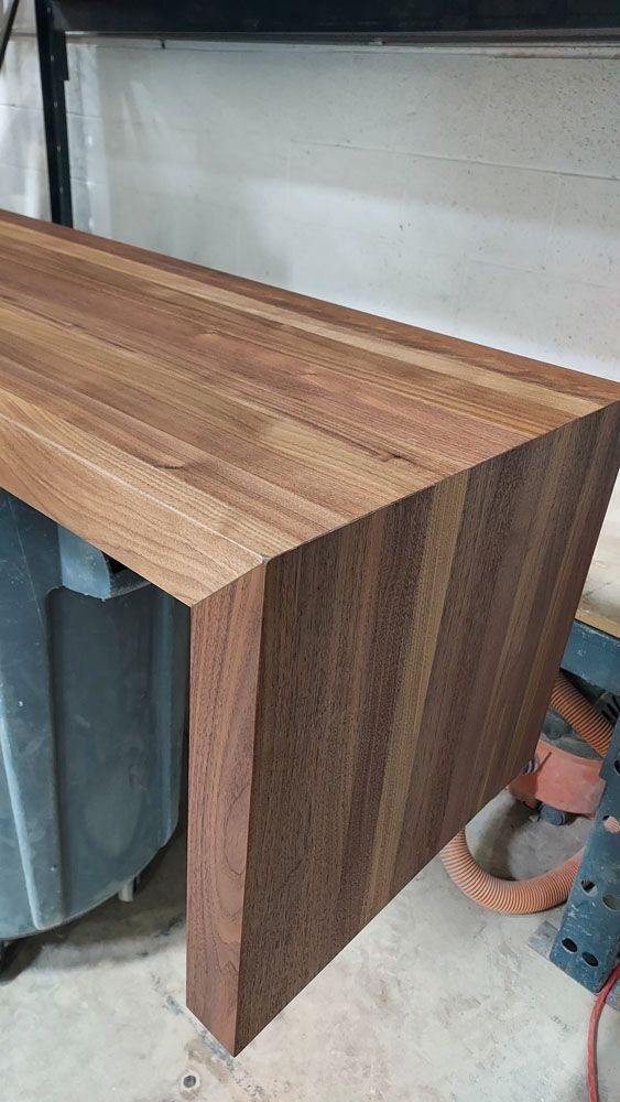 Wooden desk with visible wood grain, dark brown color, angled side.