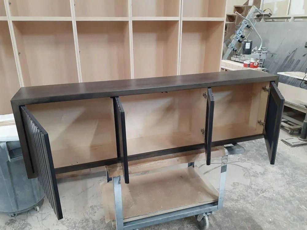 Dark brown cabinet with open doors in a workshop setting.