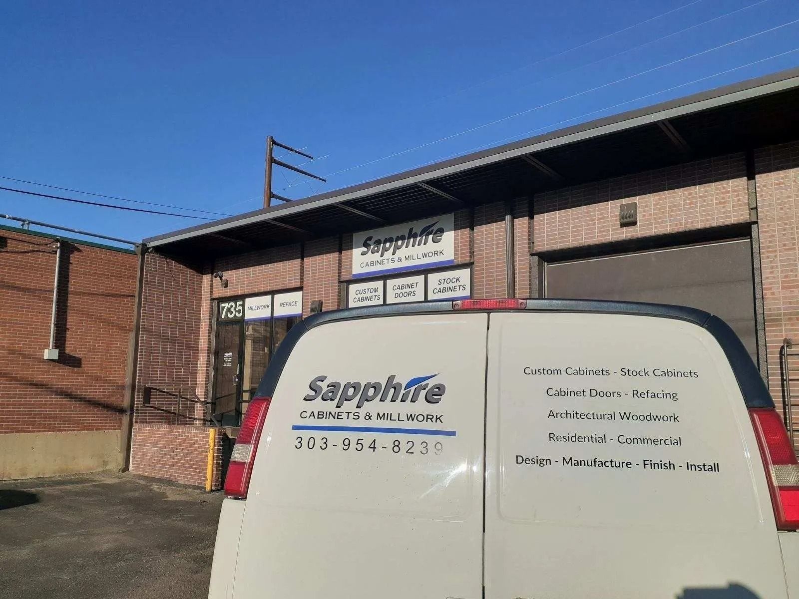 White van parked in front of a brick building with a 