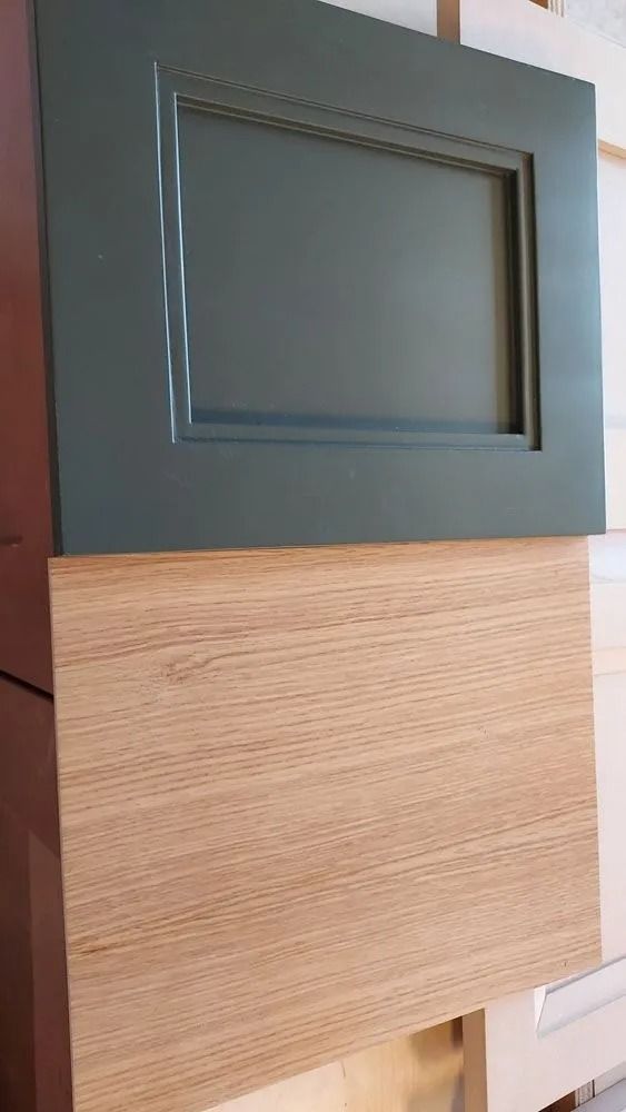 Green painted cabinet door sample above a light wood grain sample.
