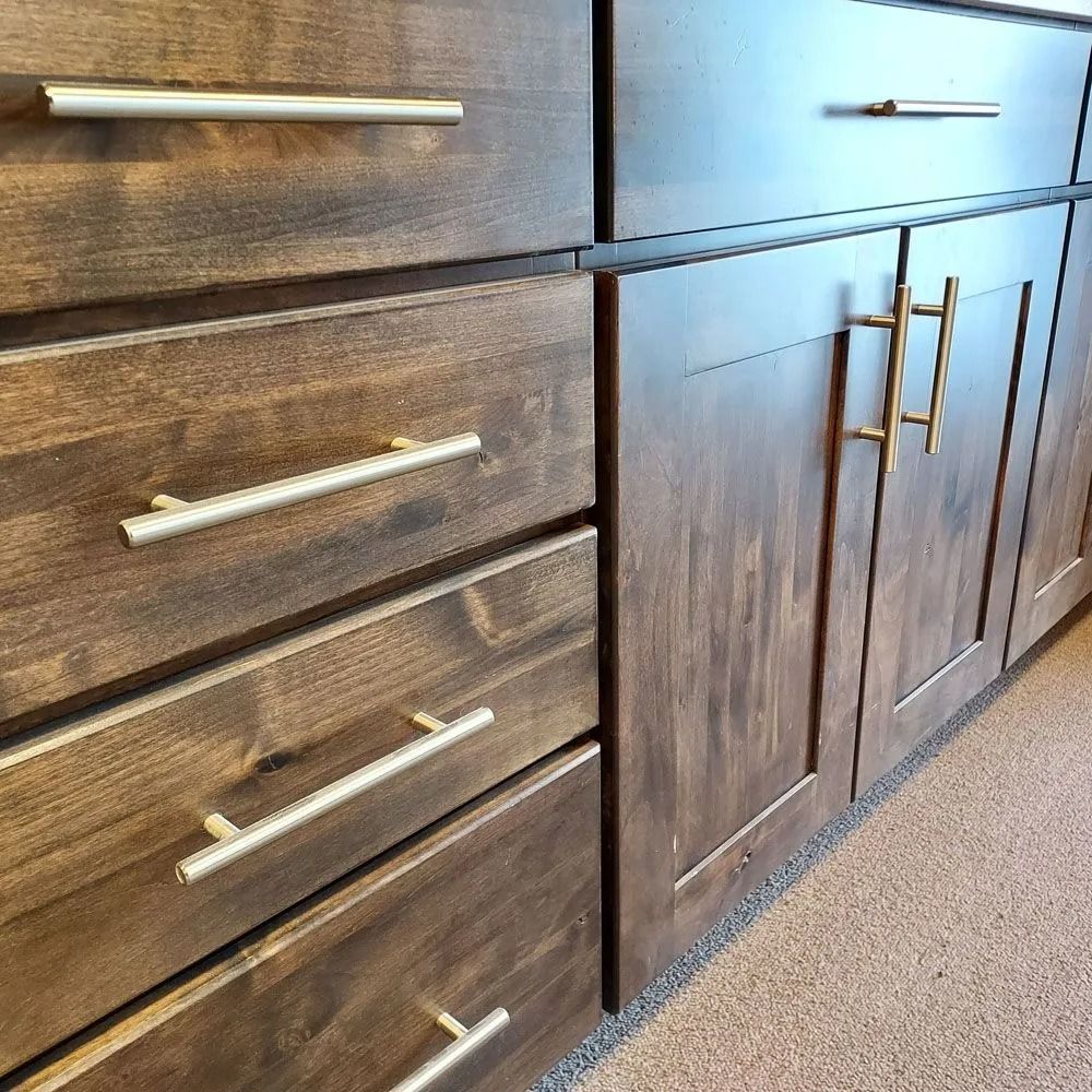 Close-up of brown kitchen cabinets with silver and gold hardware.
