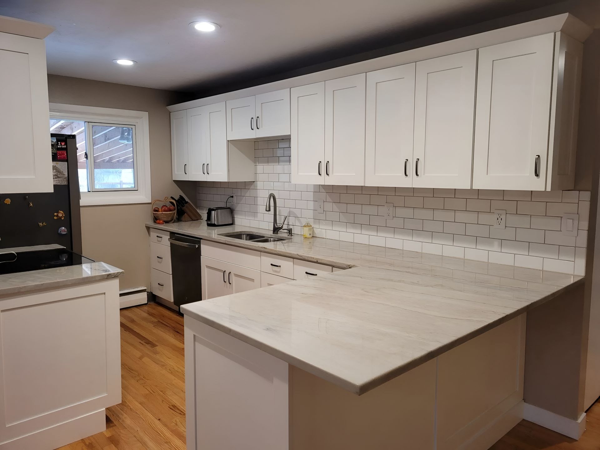 White kitchen with countertops, cabinets, and a tile backsplash.