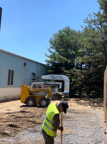 A case backhoe is moving dirt in front of a house under construction.