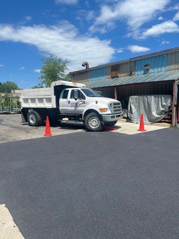 A group of construction workers are working on a driveway