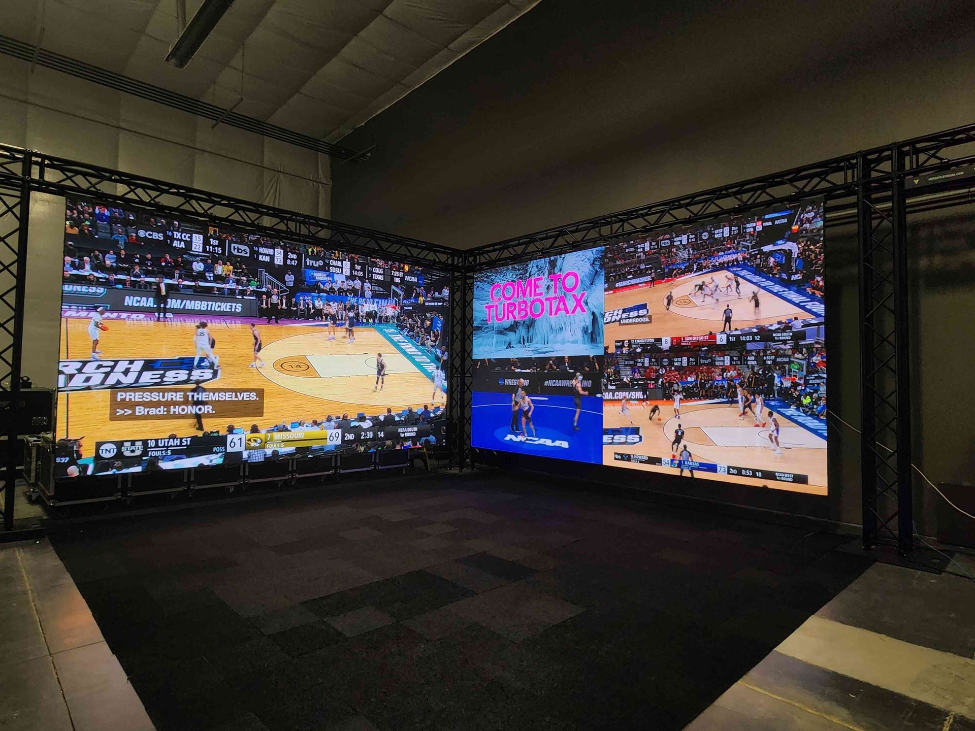 Large LED screens displaying basketball footage in a studio setting.