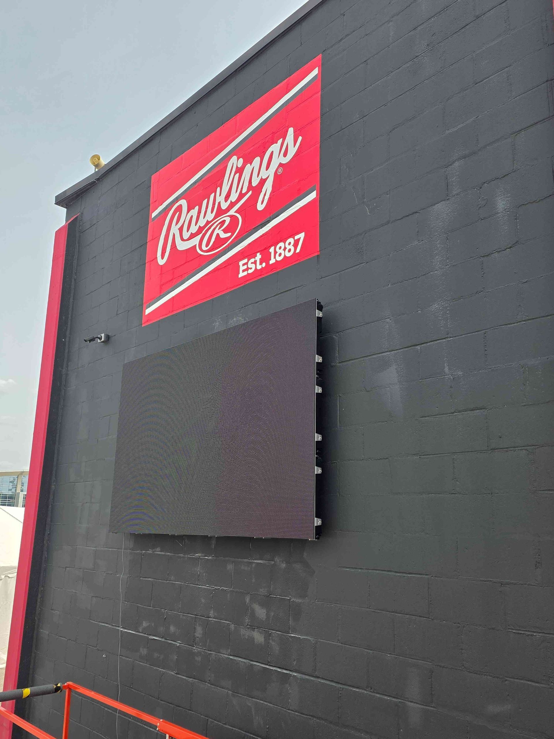 Black building with a red Rawlings logo above an LED screen.