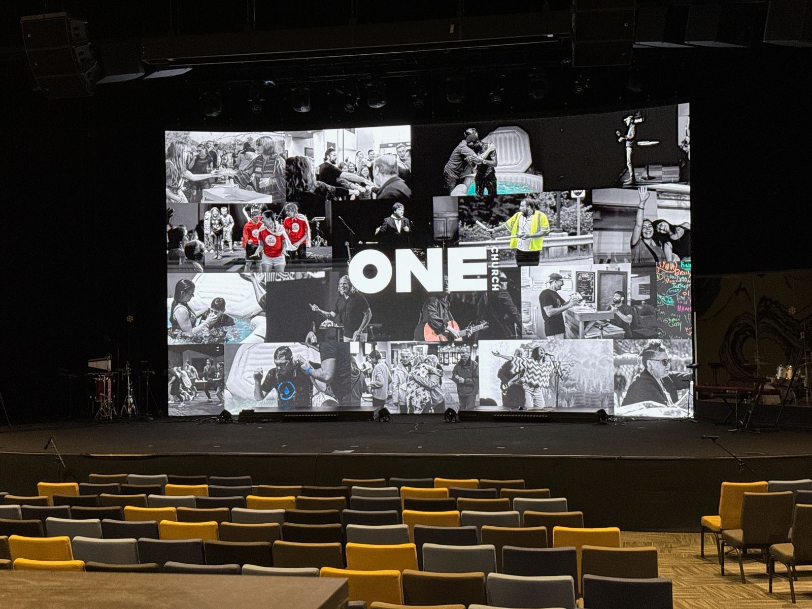 Auditorium stage with a large screen displaying 