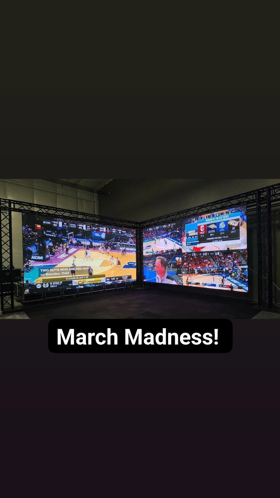 Two large screens showing a basketball game, labeled 