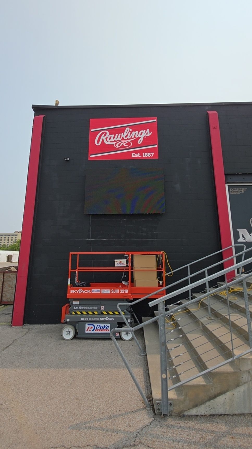Rawlings logo on black building with red accents, lift, and stairs.